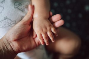 Parent holding baby's hand